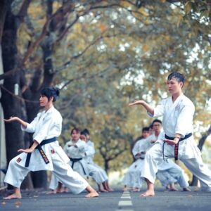 Young martial artists practice focused karate stances outdoors