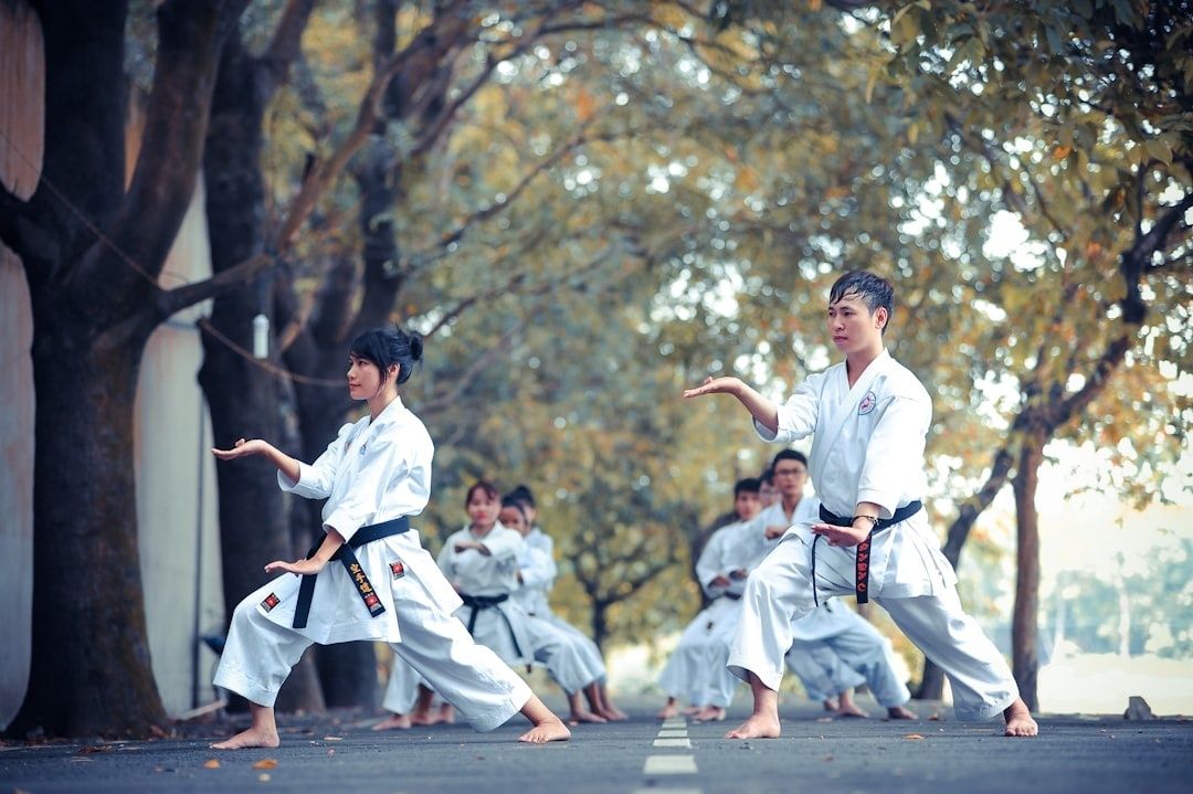 Young martial artists practice focused karate stances outdoors