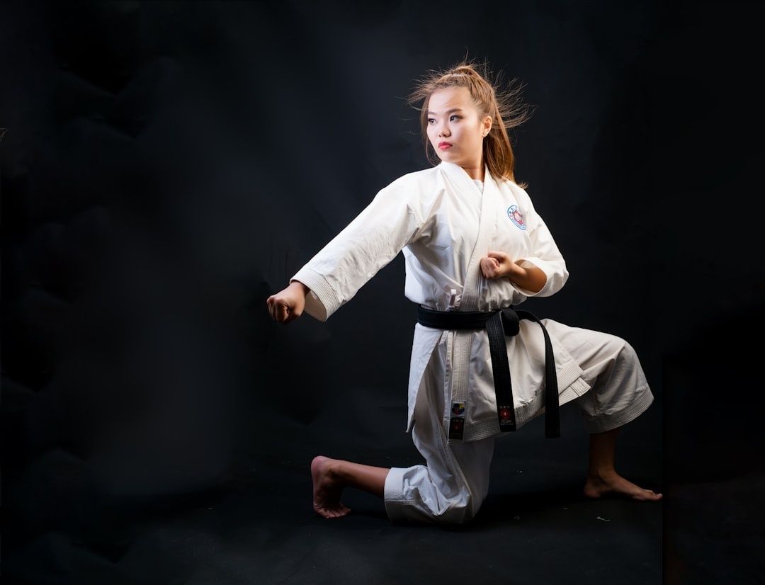 Martial artist in a white gi and black belt practicing a stance